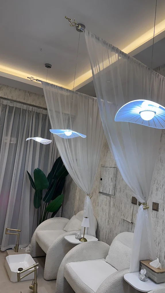 Pedicure area with cream lounge chairs and sheer curtains